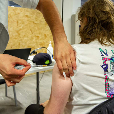 Sairaanhoitaja antaa rokotteen Jätkäsaaressa.