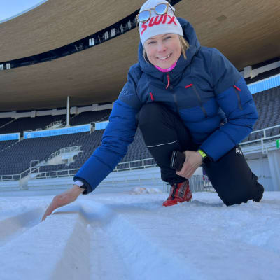 Ann-Mary Ähtävä tutkii latujen kuntoa Helsingin olympiastadionilla.