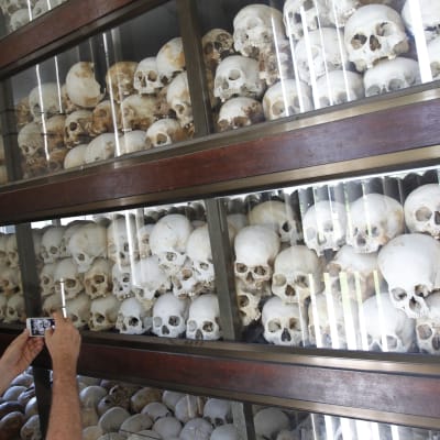 En turist fotograferar kvarlevorna av de som dog under de Röda khmerernas skräckvälde.