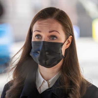 Närbild av brunhårig kvinna med svart munskydd. Statsminister Sanna Marin 31.3.2021.