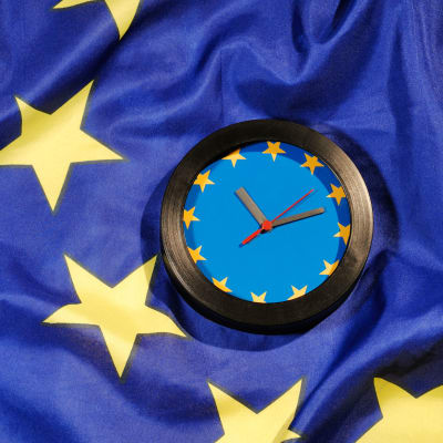 Bild föreställande en klocka med EU:s flagga i bakgrunden. 
