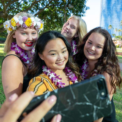 Havaijin au pairit ottavat ryhmäselfietä puhelimella