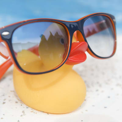 En badanka med stora glasögon framför en simbassäng.