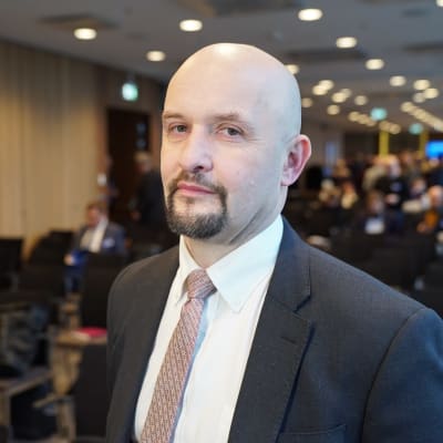 Janis Sarts, Director NATO StratCom COE seisoo hotelli Marriottin kattoneuvotteluhuoneessa seminaarin kahvitauolla.