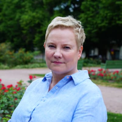 Anu Sajavaara, valtakunnansovittelija istuu Helsingissä Kirjailijanpuistossa kameraan katsoen.