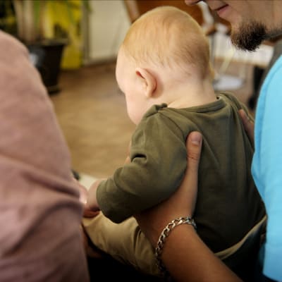 En baby med föräldrar.