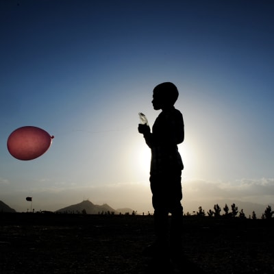 Afghansk pojke leker med en ballong i Kabul i juli 2016.