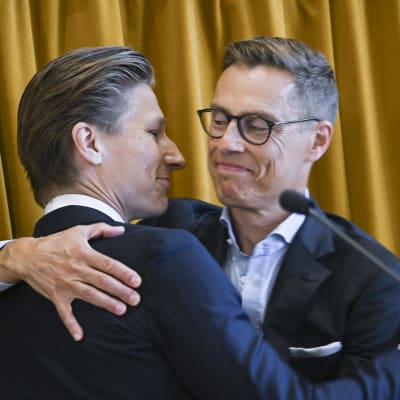 Akexander Stubb ja Antti Häkkänen halaavat toisiaan lavalla. Molemmilla hymy kasvoilla.