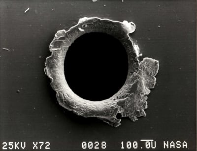 Hål i satellit efter en träff av en mikrometeorit.