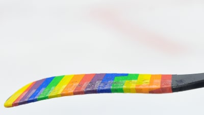 En ishockeyklubba i regnbågsfärger.