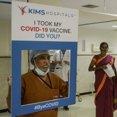En sjukhusanställd håller upp en skylt dä det står att hen tagit coronavaccin och frågar om du gjort det.