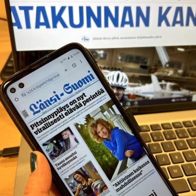 Tietokoneen ruudulla Satakunnan Kansan etusivu, tietokoneen edessä kännykän ruudulla Länsi-Suomen etusivu