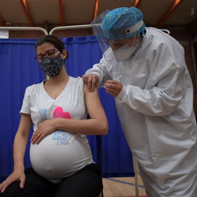Gravid kvinna sitter och får ett coronavaccin i Bogota, Colombia.