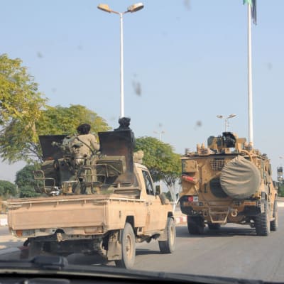 Två militärfordon på en asfalterad väg i Syrien.