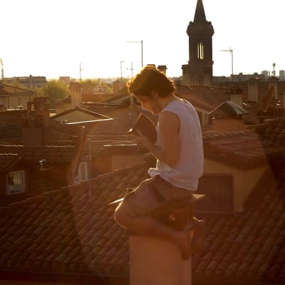 Italienska studenten Pierpaolo Mazzurco läser på taket till studentlägenheten i Bologna under coronakarantänen.