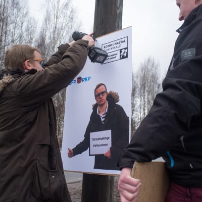 Filip Björklöf (SFP) och Eddie Lindbom (SFP) hänger up valplakat i Karis inför kommunalvalet 2017.