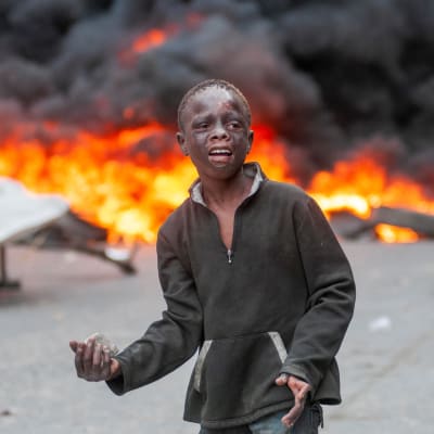 En ung pojke som deltog i stenkastningen under söndagens protester i Port-au-Prince.
