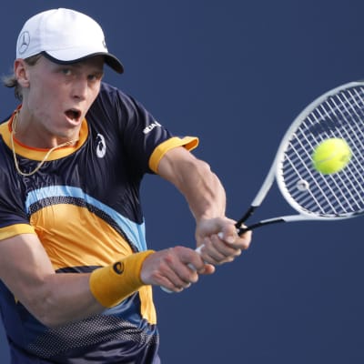 Emil Ruusuvuori i mörkblå blus slår till bollen med sin racket.