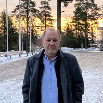 Man i mörk vinterrock står utanför ishallen i Vasa