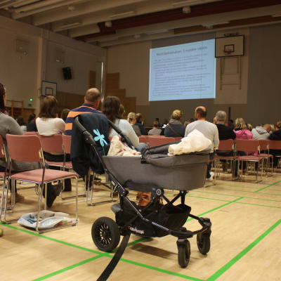 Publik med barnvagn i förgrunden.