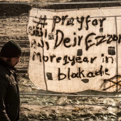 Banderoll i flyktinglägret i Calais med texten "Be för Deir Ezzor, belägrat i över ett år"
