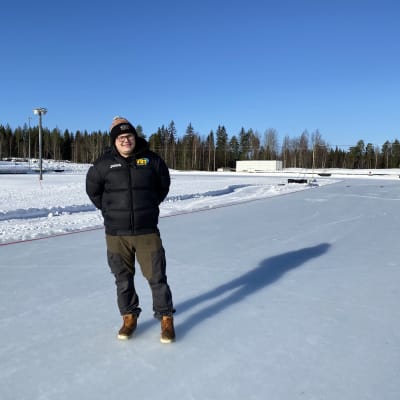 Mies seisoo tyhjällä jääspeedwayradalla.