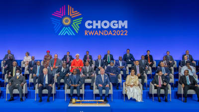 En stor grupp regeringschefer på gemensam bild, men sittande i stolar i stället för stående. I mitten av första raden sitter Rwandas president och prins Charles. Bakom samväldesledarna står det CHOGM Rwanda 2022.