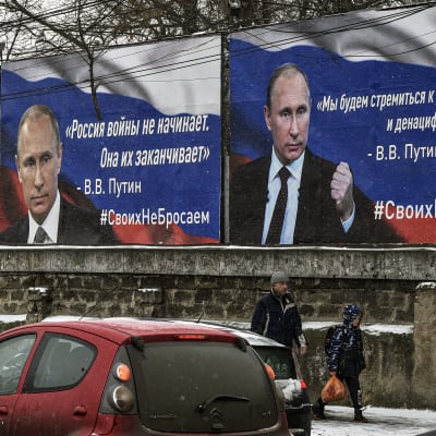 Putinia esittäviä julisteita kadun varrella.