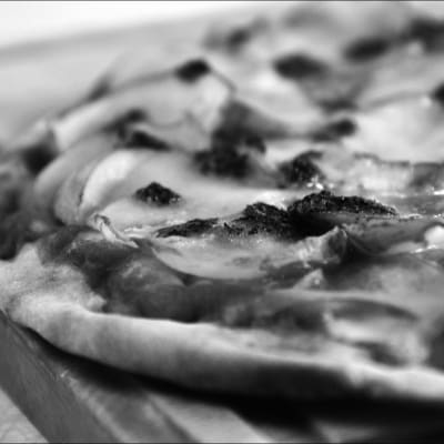 En svartvit bild på en pizza. 