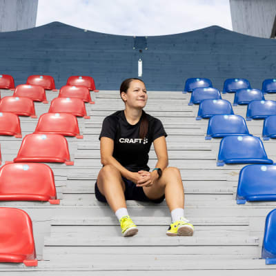 Kemiläinen futsalpelaaja Tiia Juntikka istumassa Kemin jalkapallokentän katsomon käytävällä.
