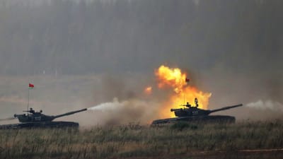 Två ryska stridsvagnar avfyrar sina kanoner under en krigsövning.