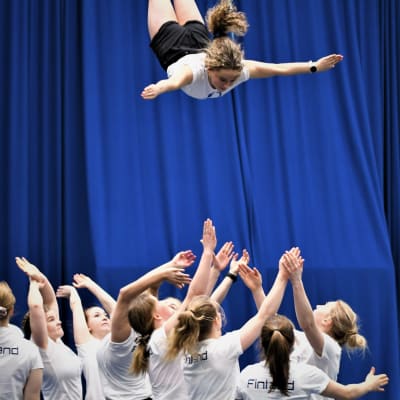 Cheerleadern Tuuve Häkkinen fångas av sina lagkamrater.