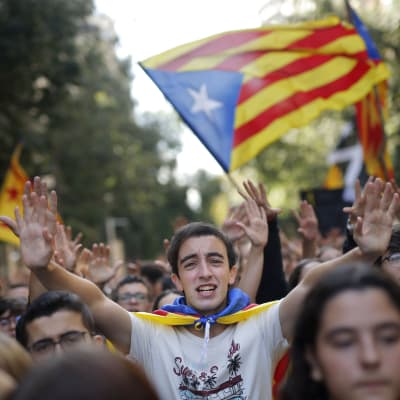 Studerande demonstrerar i Barcelona 17.10.2019. I bildens mitt står en ung man som sträcker ut båda händerna, bakom honom skymptar Kataloniens flagga. 