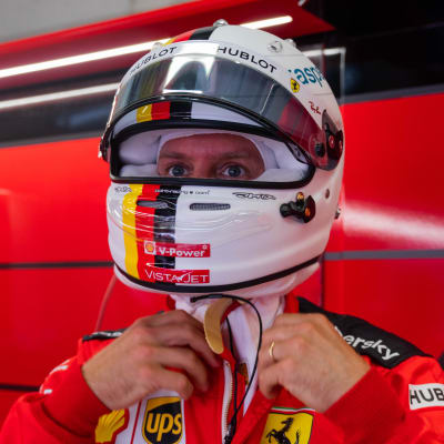 Sebastian Vettel pysslar med sin hjälm.