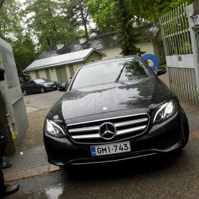 En svart bil kör ut genom grinden till statsministerns tjänstebostad Villa Bjälbo. Sannfinländarnas ordförande Jussi Halla-aho sitter i bilen.
