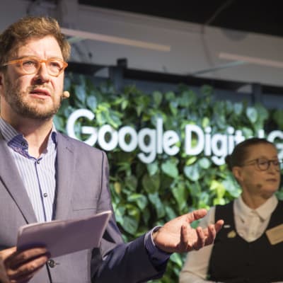 Kommunikationsminister Timo Harakka framför Google-skylt