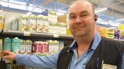 Marketschef Mika Gabrielsson står vid en butikshylla med växtmjölk.
