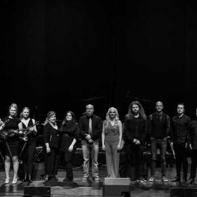 Orkesterin jäsenet lavalla mustavalkoisessa kuvassa.