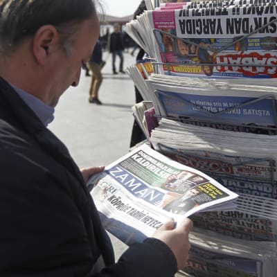 En man står och läser Zaman utanför en tidningskiosk i Istanbul på söndagen