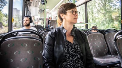 kvinna sitter i en nästan tom buss.