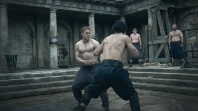 Muskulösa Arthur tränar kampsport med andra muskulösa män.