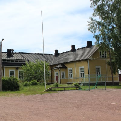Kotkan Tiutisen koulu kuvattuna kesällä. Etualalla näkyy jalkapallokenttä.
