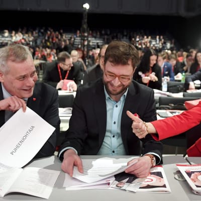 Antti Rinne, Timo Harakka och Tytti Tuppurainen sitter vid ett bord på SDP:s partikongress i Lahtis 2017. De tre kandiderar till ordförandeposten.