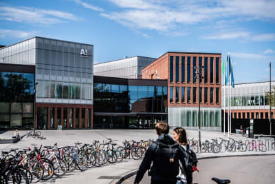 Aalto-universitetet i Esbo, ett stort antal cyklar och två personer i förgrunden.