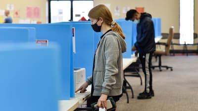 Personer i munskydd röstar i senatsvalet i Georgia, USA.