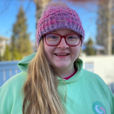 Pitkähiuksinen Commu-yrityksen Karoliina Kauhanen katsoo pipo päässä kameraan ja hymyilee.