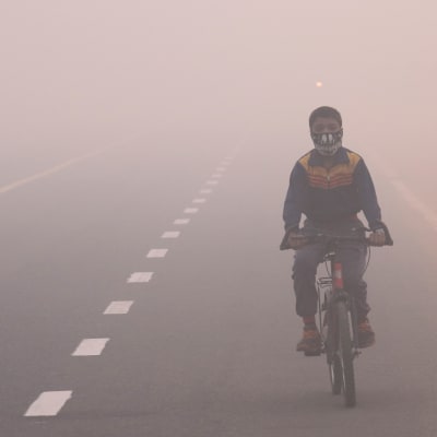 En indier åker motorcykel i smog efter Diwali festivalen i New Delhi i slutet av oktober 2016.