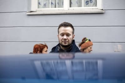 Demian Seesjärvi seisoo kadulla silmät kiinni. Edessä on auton katto, josta heijastuu Demianin kuva. Taustalla kävelee kaksi naista.