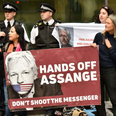 Människor protesterar och håller upp skyltar för Julian Assange i London 14.6.2019.