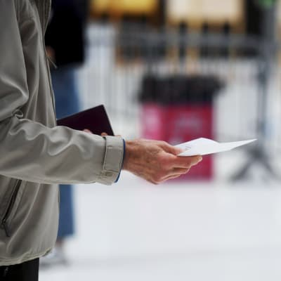 En person har fått en röstsedel och instrueras av en valfunktionär
